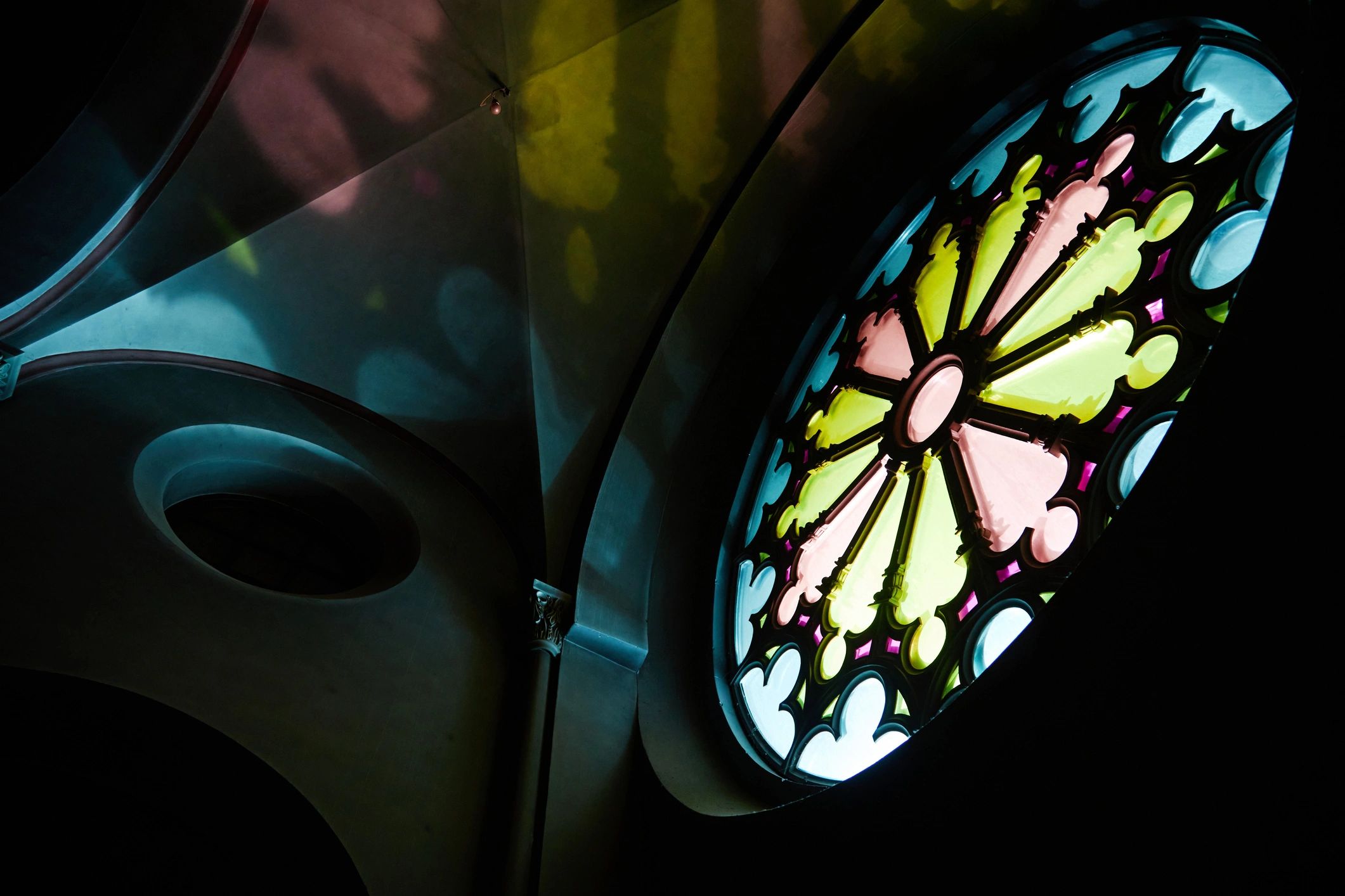 Stained glass window casting gentle colors, suggesting hope