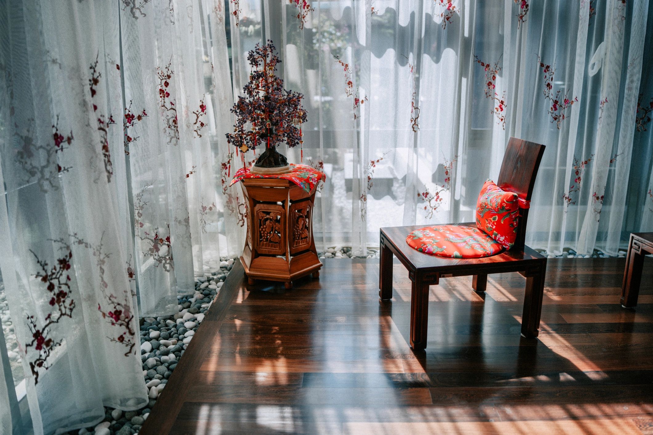 Sunlit quiet corner with chair and soft cushion, evoking a calm home sanctuary