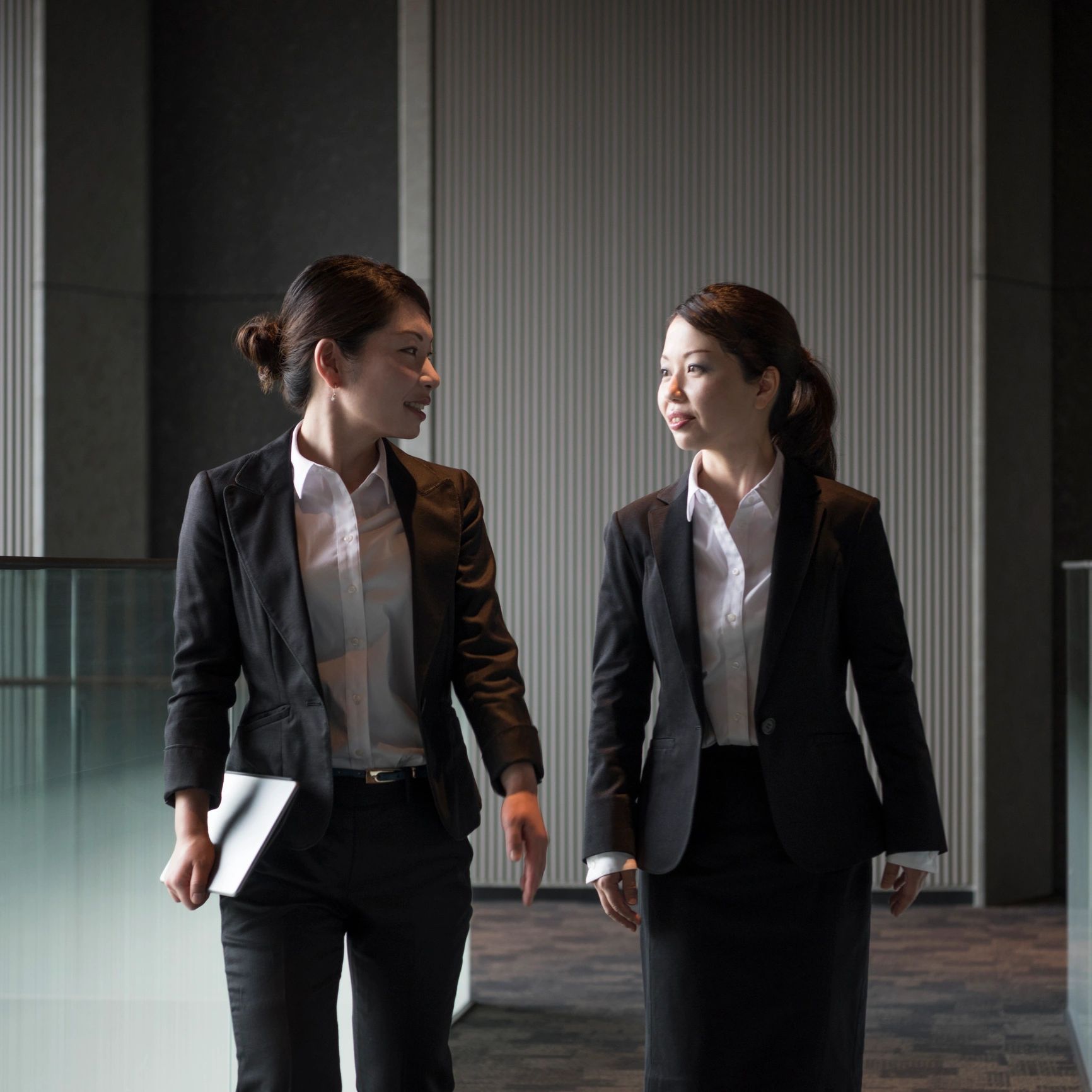 Two women walking and talking in a modern setting